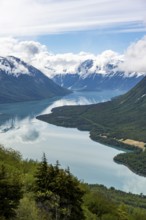 View of snowy mountains in spring and turquoise Kenai Lake with reflection, Slaughter Ridge Trail,