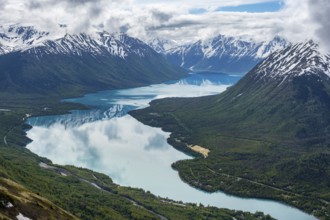View of snowy mountains in spring and turquoise Kenai Lake with reflection, Slaughter Ridge Trail,