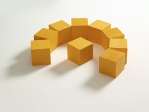9 yellow wooden cubes against a white background