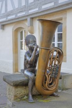 Sculpture boy with tuba by Guido Messer 1991, modern art, bronze sculpture, playing music, tuba,