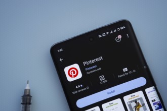 Dhaka, Bangladesh- 29 May 2025: On a blue surface, a smartphone displays the Pinterest app within