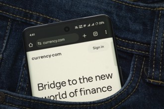 Dhaka, Bangladesh- 15 June 2025: A smartphone displaying the Currency.com web interface peeks out
