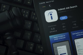 Dhaka, Bangladesh- 28 Oct 2025: An iPad displaying the Indeed app against a judge's gavel and dark