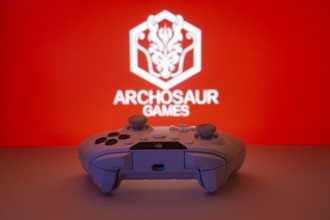 Dhaka, Bangladesh- 08 Apr 2025: A gaming controller in front of a Archosaur Games screen