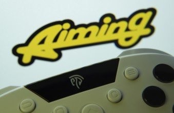 Dhaka, Bangladesh- 24 Mar 2025: A close-up of a gamepad with the Aiming Inc seen on screen in the