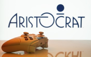 Dhaka, Bangladesh- 20 Mar 2025: A close-up of a white gamepad with the Aristocrat seen on screen in