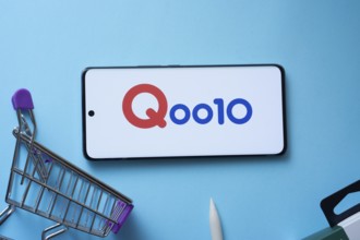 Dhaka, Bangladesh- 03 July 2025: Smartphone displaying Qoo10 logo with shopping cart on a blue