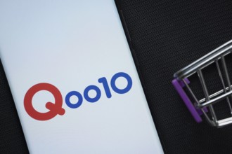 Dhaka, Bangladesh- 03 July 2025: A smartphone displaying the Qoo10 logo next to a miniature