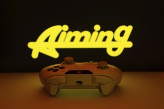 Dhaka, Bangladesh- 08 Apr 2025: A gaming controller in front of a Aiming Inc screen