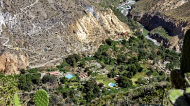 Small village surrounded by a green oasis in a rocky gorge landscape, the landscape of the Colca