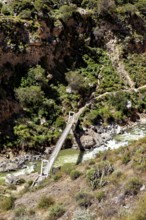 Wooden bridge over emerald-colored river, nestled in a rich rocky landscape, The landscape of the