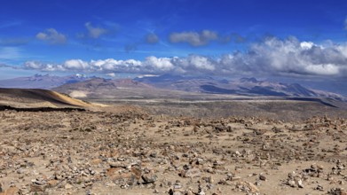 Stone area under blue sky with rising clouds in the distance, The highlands of the Andes of Peru