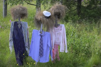 Artwork outdoor installation The silent people of Reijo Kela Straw dolls wear colorful clothes in a