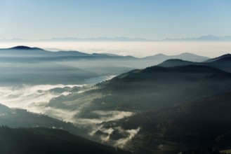 View from Belchen heading south of Wiesental and the Swiss Alps, morning atmosphere with fog in