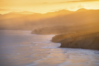 Wairarapa coast at sunset. Sea, mountains, backlight. Castlepoint, Wairarapa Coast, Wellington