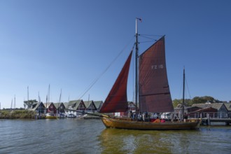 Zeesboot, former historic fishing boat, leaves the port of Ahrenshoop, blue sky, Darß,