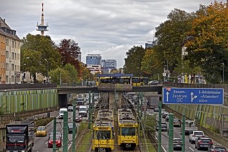 Lots of traffic on the A 40 motorway on four lanes and two subways on two lanes and a bus on the