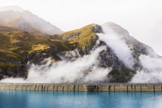Fog rises over the dam of the Lac de Moiry Reservoir, Val d'Anniviers, Valais Alps, Canton of
