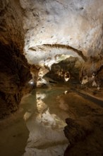 Stalactites and stalagmites, reflection in a small underground lake, rock formations in a