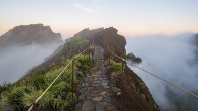 Sunrise at Pico do Arieiro, clouds of fog sweep over mountain peaks, sea of fog, hiking trail PR1,