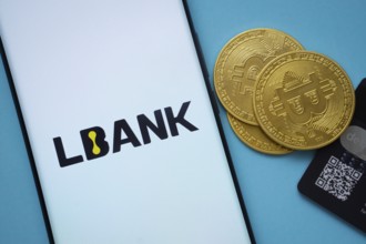 Dhaka, Bangladesh- 03 Sep 2025: Lbank logo on smartphone screen near Bitcoin coin and QR code on