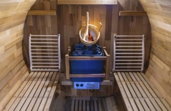 Steam and hot stone wooden cedar compact sauna interior with heating stone electrical device, hot