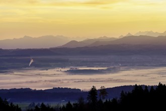 View from Horben of the Reuss Valley covered in fog, behind it the Glarus Alps in the light of the