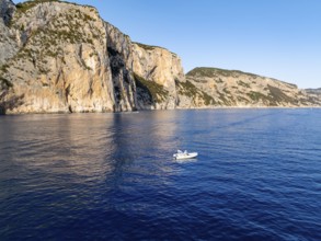 Motorboat off picturesque rocky coast ImmorgenLicht, cliffs, Golfo di Orosei, Baunei, Sardinia,