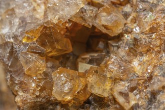 Shiny crystals of blue and orange color can be seen in this mineral formation. They are sparkling