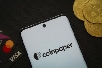 Dhaka, Bangladesh- 03 Sep 2025: Smartphone displaying Coinpaper surrounded by Bitcoin coins and
