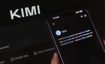 In this photo illustration, a person uses the Kimi AI chatbot on a smartphone while the KIMI logo