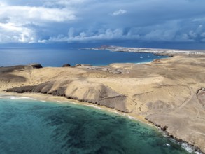 Coast with Playa Caleta del Congrio beach and blue sea, arid landscape of Los Ajaches Natural Park,