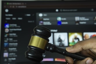 Dhaka, Bangladesh- 20 June 2025: A hand holds a gavel in front of a computer screen displaying