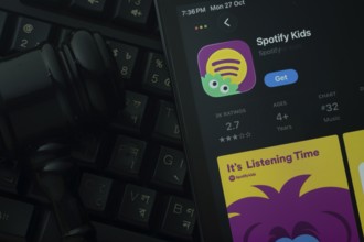 Dhaka, Bangladesh- 28 Oct 2025: An iPad displaying the Spotify Kids app against a judge's gavel and