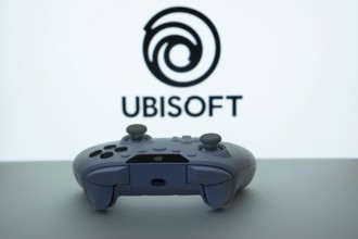 Dhaka, Bangladesh- 14 Nov 2025: A close-up of a white gamepad with the Ubisoft seen on screen in