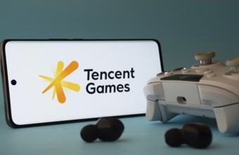 Dhaka, Bangladesh- 23 Mar 2025: A smartphone with a Tencent Games icon next to a controller and