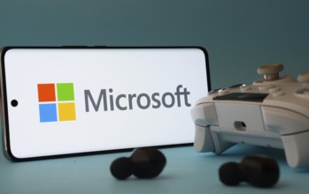 Dhaka, Bangladesh- 23 Mar 2025: A smartphone with a Microsoft icon next to a controller and earbuds