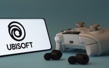 Dhaka, Bangladesh- 23 Mar 2025: A smartphone with a Ubisoft icon next to a controller and earbuds