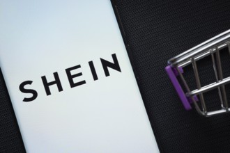 Dhaka, Bangladesh- 03 July 2025: A smartphone displaying the SHEIN logo next to a miniature