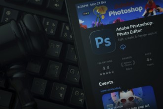 Dhaka, Bangladesh- 28 Oct 2025: An iPad displaying the Adobe Photoshop app against a judge's gavel