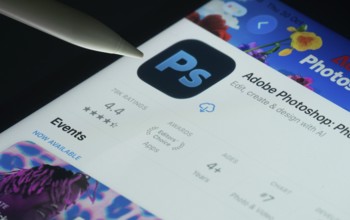 Dhaka, Bangladesh- 30 Oct 2025: Adobe Photoshop app on a iPad screen with a pen pointing at the