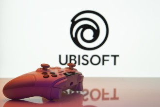 Dhaka, Bangladesh- 14 Nov 2025: A close-up of a white gamepad with the Ubisoft seen on screen in
