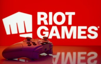 Dhaka, Bangladesh- 14 Nov 2025: A close-up of a white gamepad with the Riot Games seen on screen in