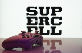 Dhaka, Bangladesh- 14 Nov 2025: A close-up of a white gamepad with the Supercell seen on screen in