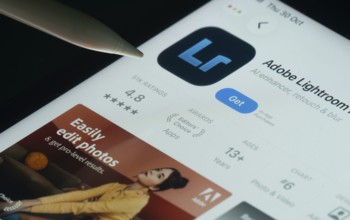 Dhaka, Bangladesh- 30 Oct 2025: Adobe Lightroom app on a iPad screen with a pen pointing at the