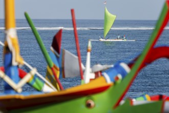 Colourfully painted outrigger fishing boats, (Junkung), on Sanur beach, Bali, Indonesia