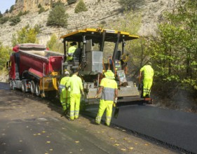 Asphalt road construction team of workers resurfacing tarmac in rural area, near Albarracin, Teruel