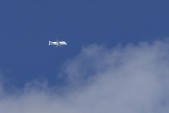 Airbus A330-743L Beluga XL cargo jet aircraft flying in a blue sky with white clouds, England,