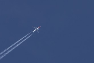 Boeing 737 jet passenger aircraft of Norwegian Air airlines flying in a blue sky with contrails or