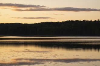 Clouds reflected on the water surface, forest lake, evening mood, at Sunne, Sweden